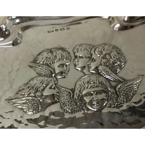 425 - A large silver tray chased with cherubs. 1916. By William Aitken. Approx. 201 grams. Est. £200 - £30... 