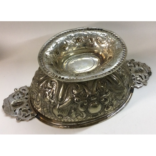 438 - An Antique 19th Century Dutch silver chased bowl with pierced handles. Marked to base. Appro. 345 gr... 