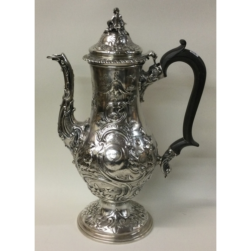 454 - A large chased silver coffee pot with chinoiserie decoration embellished with figures. London 1762. ... 