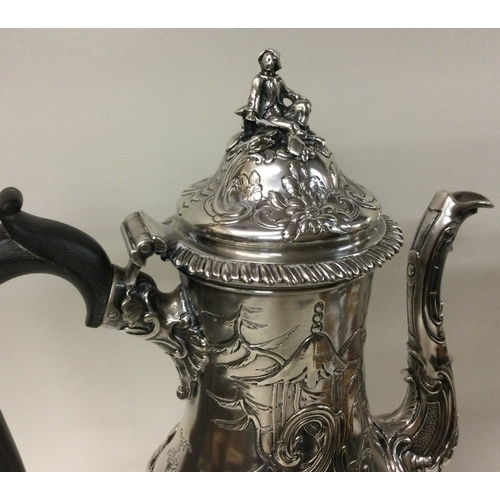 454 - A large chased silver coffee pot with chinoiserie decoration embellished with figures. London 1762. ... 