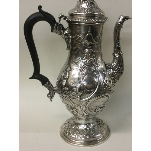 454 - A large chased silver coffee pot with chinoiserie decoration embellished with figures. London 1762. ... 