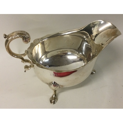 524 - A heavy Georgian style silver sauce boat with card cut rim. Approx. 259 grams. Est. £70 - £80.