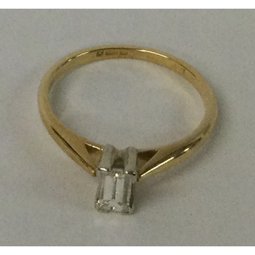 544 - A diamond single stone baguette cut ring in two colour 18 carat gold setting. Approx. 2 grams. Est. ... 