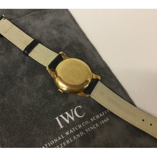 586 - IWC (International Watch Company): A good 18 carat gold wristwatch with date aperture on leather str... 