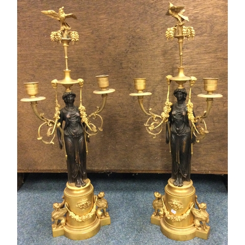 639 - A fine pair of bronze candlesticks in the form of figures with swag decoration and bird finials. Est... 