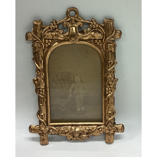 670 - A small gilt picture frame with domed top. Est. £20 - £30.