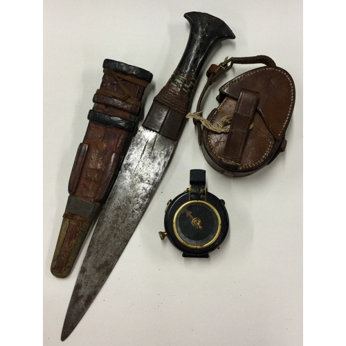 689 - An old brass mounted compass together with a dagger. Est. £20 - £30.