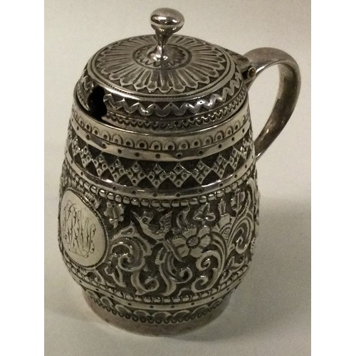 7 - An Indian silver mustard pot chased with animals. Approx. 74 grams. Est. £50 - £80.