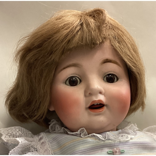 701 - A large German porcelain headed doll. Est. £40 - £60.