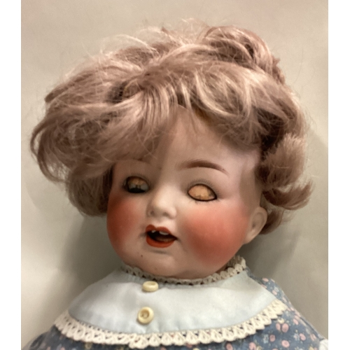 702 - A large German porcelain headed doll. Est. £40 - £60.