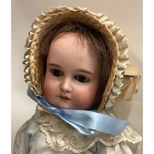 703 - A large German porcelain headed doll. Est. £40 - £60.