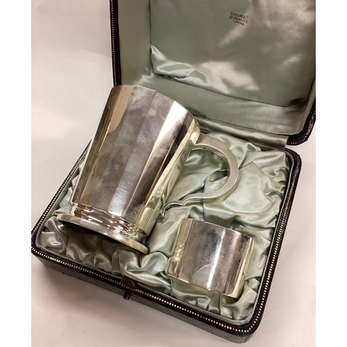 71 - A cased silver presentation mug and napkin ring. London 1912. By Wakely & Wheeler. Retailed by Tiffa... 