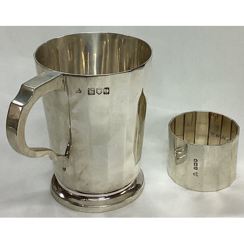 71 - A cased silver presentation mug and napkin ring. London 1912. By Wakely & Wheeler. Retailed by Tiffa... 