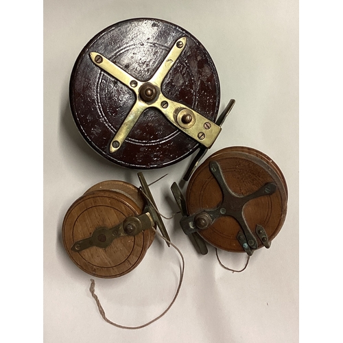 710 - Three wooden mounted fishing reels. Est. £30 - £40.