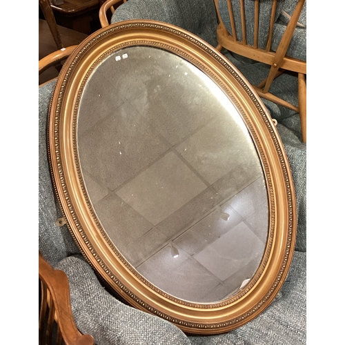 717 - A large gilt framed oval mantle mirror. Est. £20 - £30.