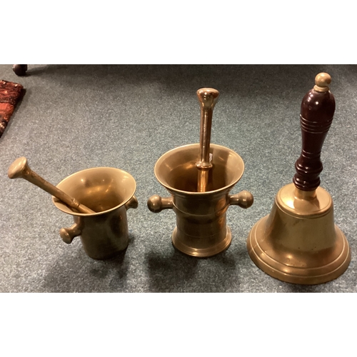 733 - Two brass pestle and mortars together with a hand bell. Est. £20 - £30.