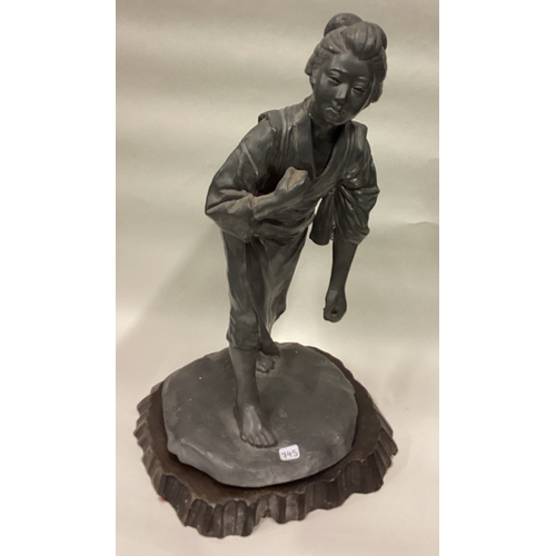 745 - An unusual pewter figure of a Chinese lady on hardwood base. Est. £30 - £40.