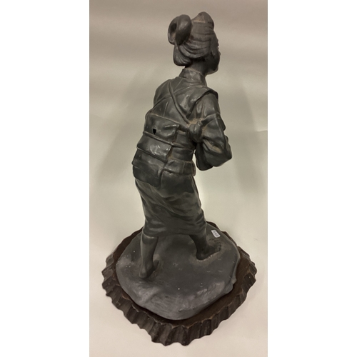 745 - An unusual pewter figure of a Chinese lady on hardwood base. Est. £30 - £40.