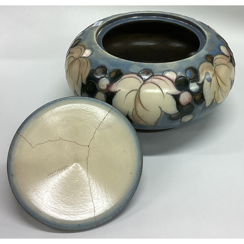 777 - WILLIAM MOORCROFT: A squat powder jar and cover decorated with leaves and berries. Est. £100 - £150.