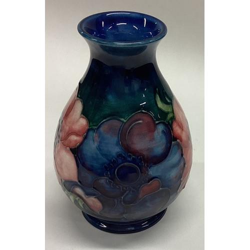 778 - WILLIAM MOORCROFT: A small pottery vase decorated with flowers. Est. £30 - £50.