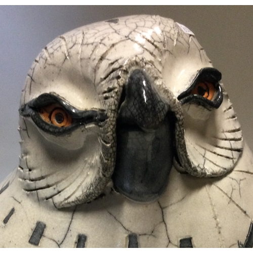 854 - JENNY HALE: A large pottery model of a snowy owl of stylised form. Est. £100 - £200.