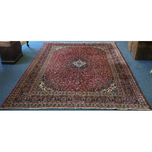 916 - A good large red ground carpet with tassel decoration. Approx. 190 cms x 380 cms. Est. £200 - £300.