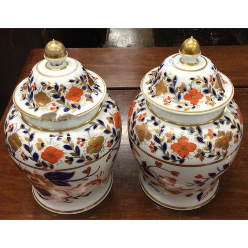 923 - Two Imari style porcelain vases with matching lids. Est. £20 - £30.