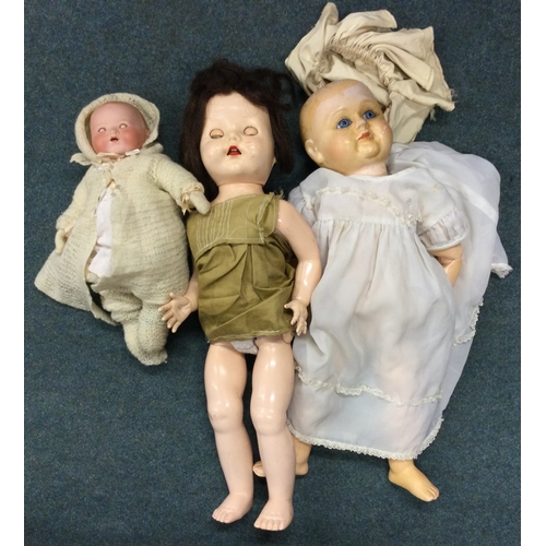 985 - An old German porcelain headed doll with noise box together with two others. Est. £20 - £30.