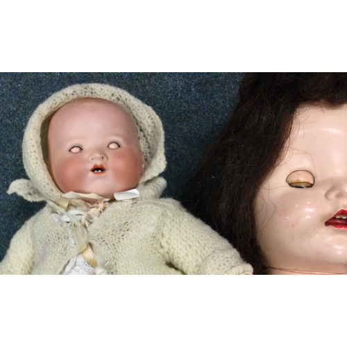 985 - An old German porcelain headed doll with noise box together with two others. Est. £20 - £30.