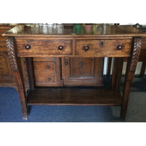 1667 - A good carved oak two drawer side table on fluted supports. Est. £60 - £80.