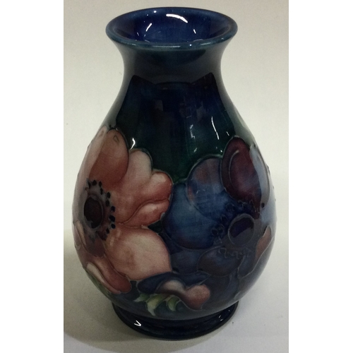 778 - WILLIAM MOORCROFT: A small pottery vase decorated with flowers. Est. £30 - £50.