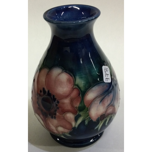 778 - WILLIAM MOORCROFT: A small pottery vase decorated with flowers. Est. £30 - £50.