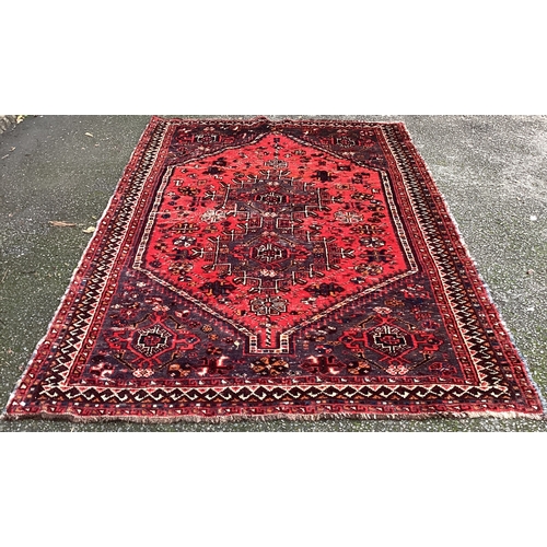 1673 - A small Oriental rug in red ground. Approx. 150 cms x 220 cms. Est. £50 - £80.