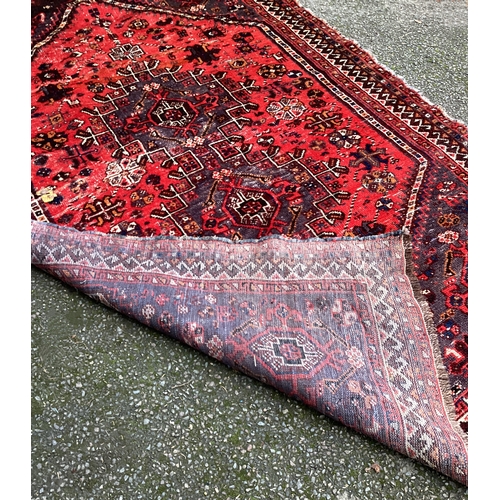 1673 - A small Oriental rug in red ground. Approx. 150 cms x 220 cms. Est. £50 - £80.