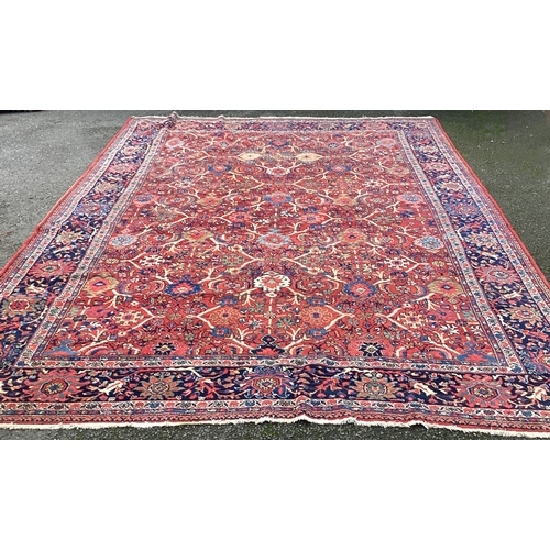 1674 - A large red ground carpet decorated in bright colours. Approx. 275 cms x 340 cms. Est. £100 - £150.