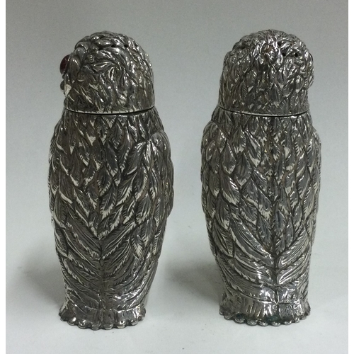 103 - A pair of silver peppers in the form of owls with red eyes. Approx. 125 grams. Est. £200 - £300.