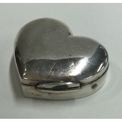 107 - A heart-shaped silver pill box with hinged lid. Marked to base. Approx. 21 grams. Est. £20 - £30.