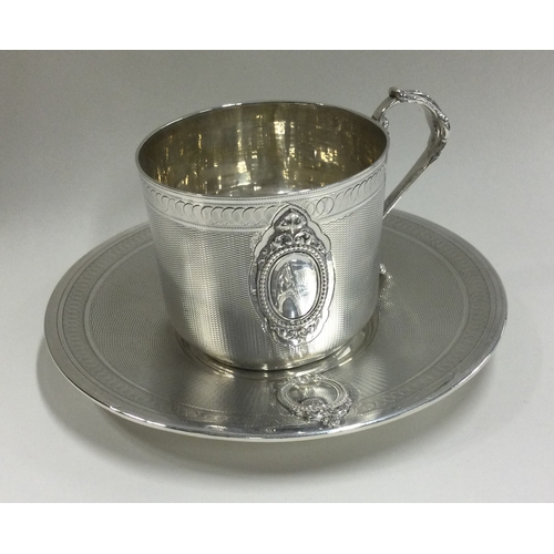 129 - A French silver cup and saucer with engine turned decoration. Retailed by Hamilton & Co. Approx. 181... 