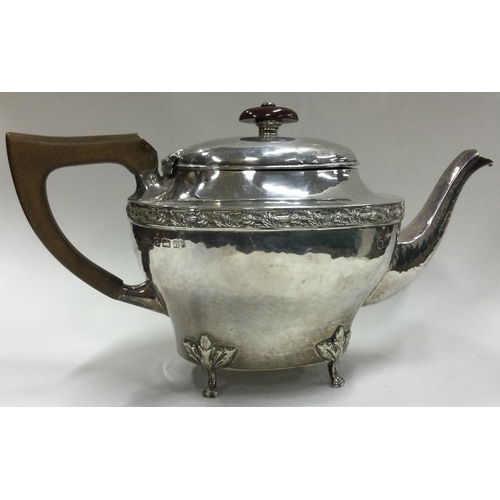 161 - A E JONES: A silver teapot on feet. Birmingham 1919. Approx. 385 grams. Est. £250 - £300.