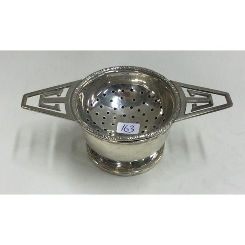 163 - A silver tea strainer on stand. Birmingham. Approx. 59 grams. Est. £80 - £120.