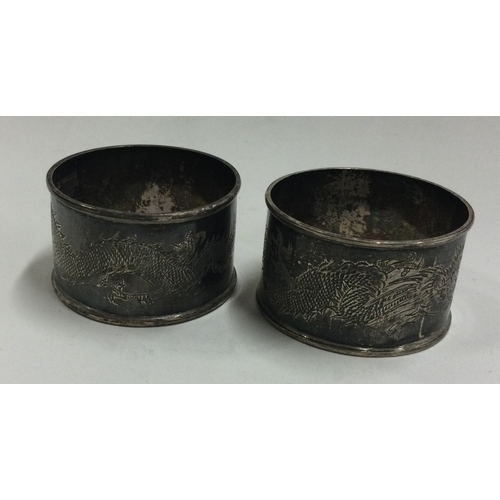 192 - A pair of engraved Chinese silver napkin rings. Approx. 46 grams. Est. £40 - £60.