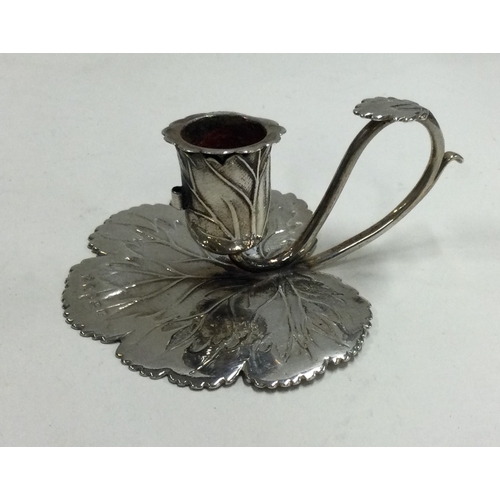 213 - A George III silver chamberstick chased with leaf decoration. Birmingham 1826. By Joseph Willmore. A... 