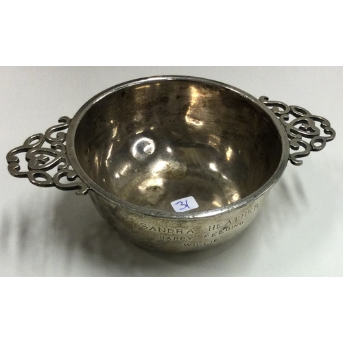 31 - A heavy silver two handled bowl with scroll decoration. Approx. 117 grams. Est. £30 - £40.