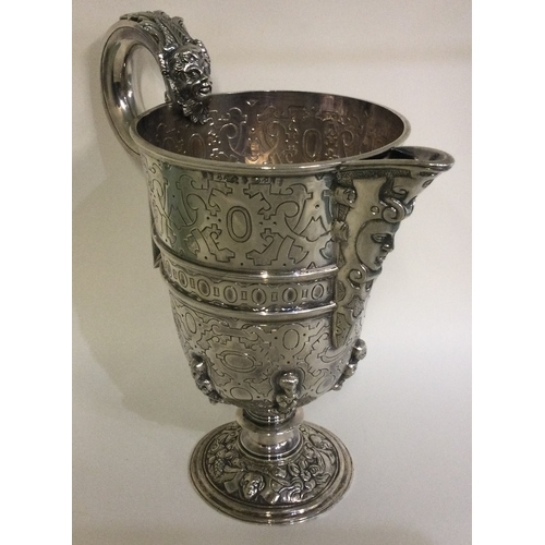 369 - A heavy chased figural Continental silver jug. Marked to body. Approx. 830 grams. Est. £500 - £800.