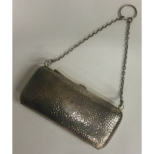 432 - A silver purse of hammered design on suspension chain. Birmingham 1906. By W Turner. Approx. 90 gram... 