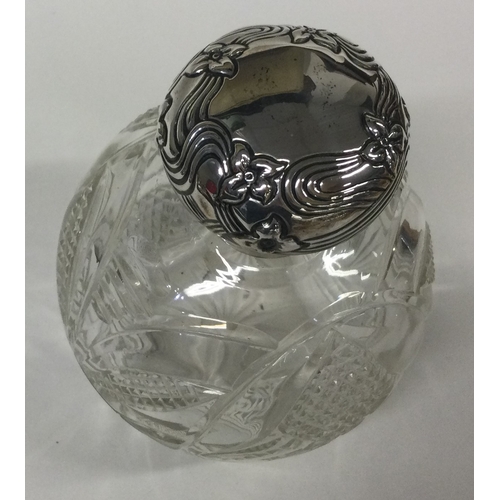 448 - A silver and glass scent bottle with hinged top and chased decoration. Birmingham. Est. £80 - £120.