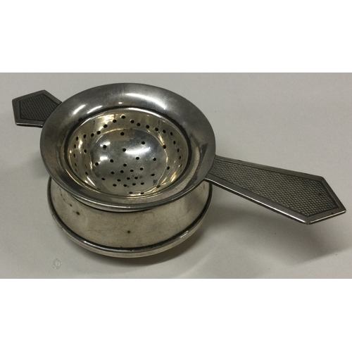 496 - An Art Deco silver tea strainer on stand. Birmingham 1959. By S&M. Approx. 55 grams. Est. £100 - £15... 