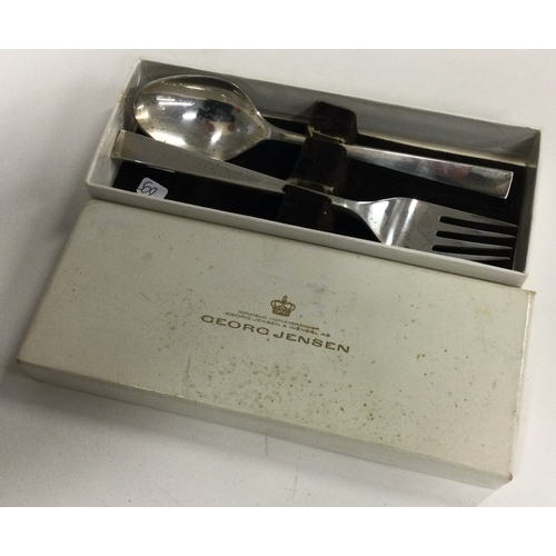 509 - GEORG JENSEN: A cased silver christening spoon and fork. Marked to base. Approx. 199 grams. Est. £10... 