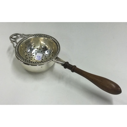 69 - A silver tea strainer on stand. Birmingham. Approx. 52 grams. Est. £100 - £150.