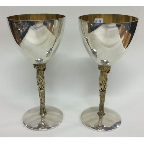 149 - STUART DEVLIN: A good pair of commemorative Silver Jubilee silver and silver gilt goblets with ram s... 